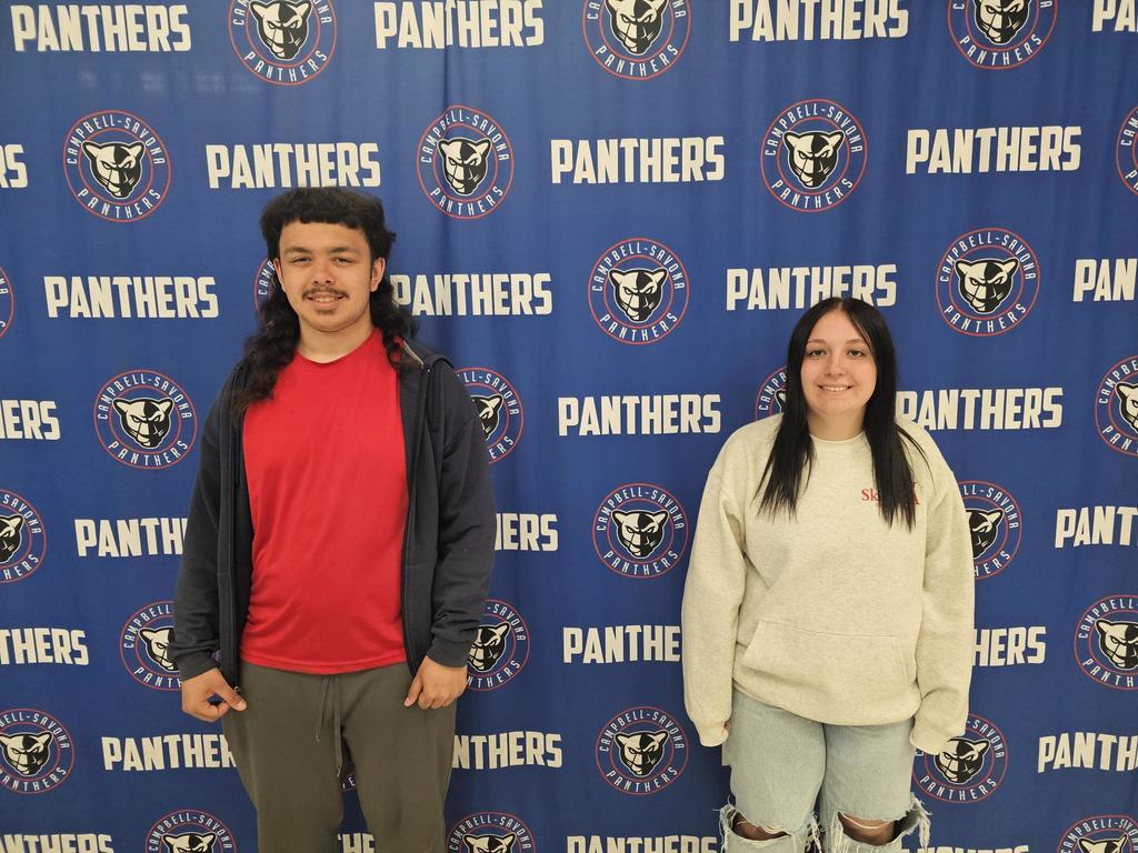 Two students standing in front of panther banner