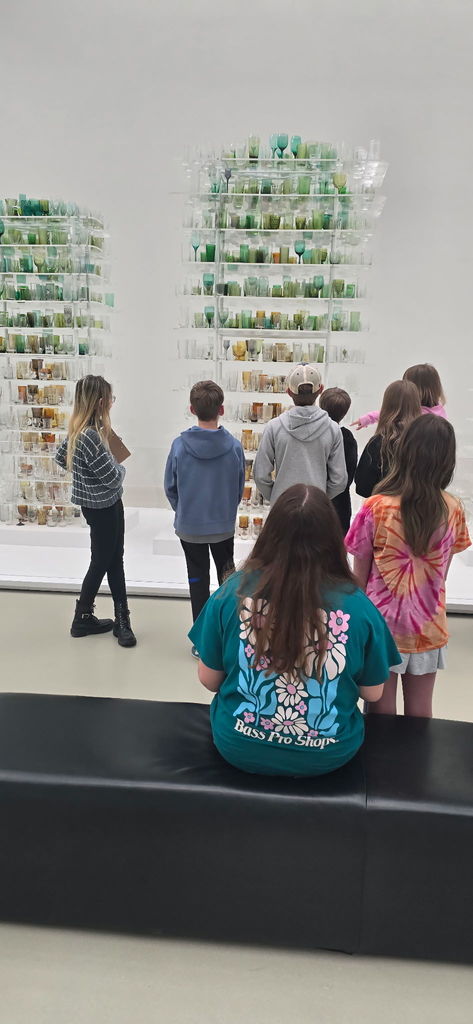 Students looking at blown glass on shelves