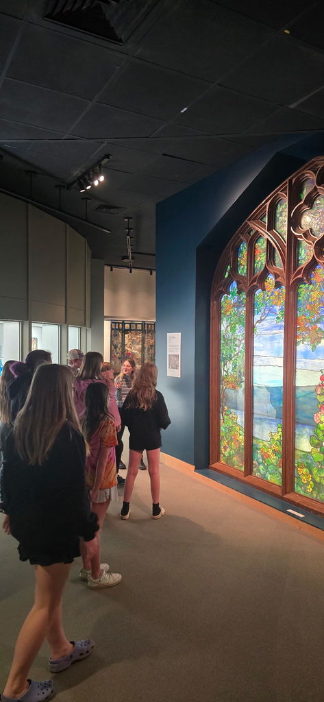 Students standing in front of glass art