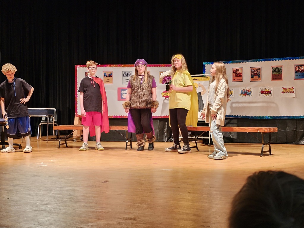 Students on stage dressed as superheroes