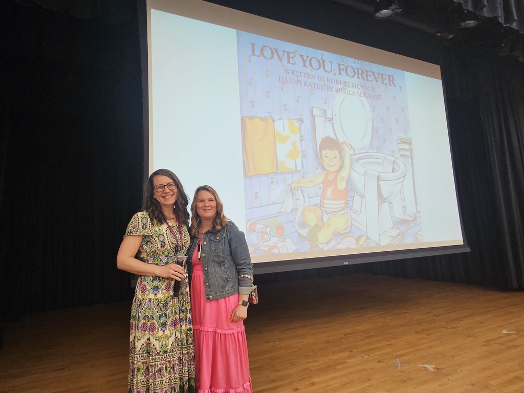 Two woman in dresses standing on stage