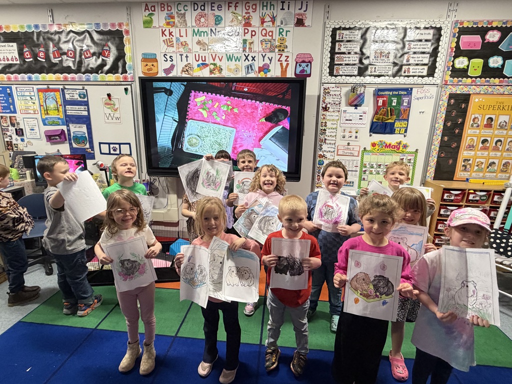 Class of students holding pictures of guini pigs