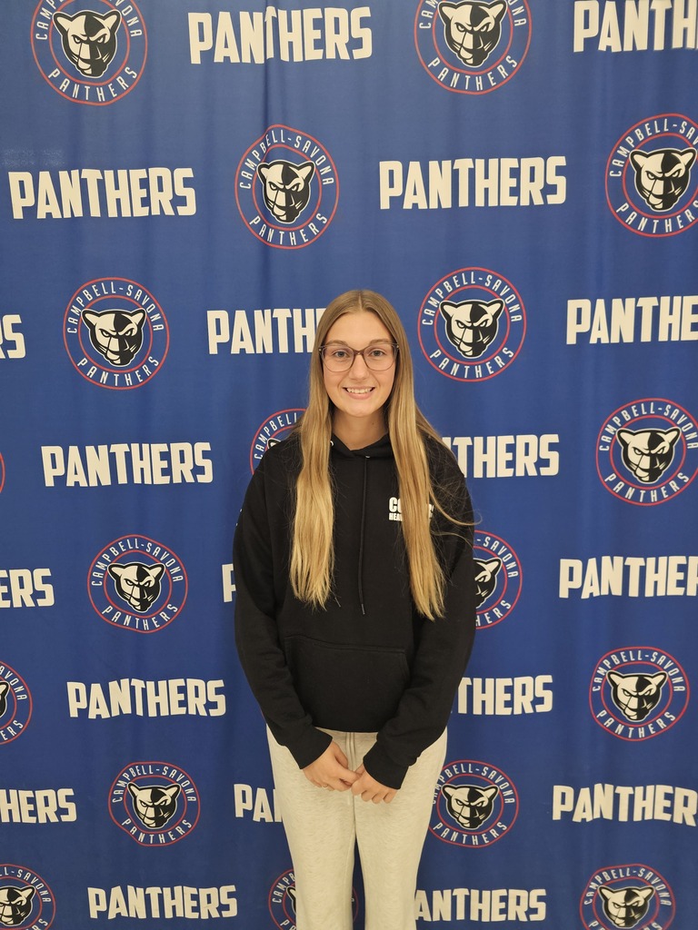 Student in front of panther banner wtih glasses and blond haire