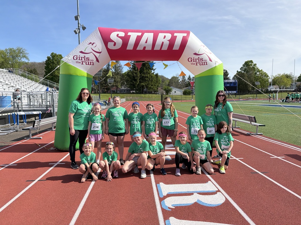 Girls in green shirts in front of start balloon on track