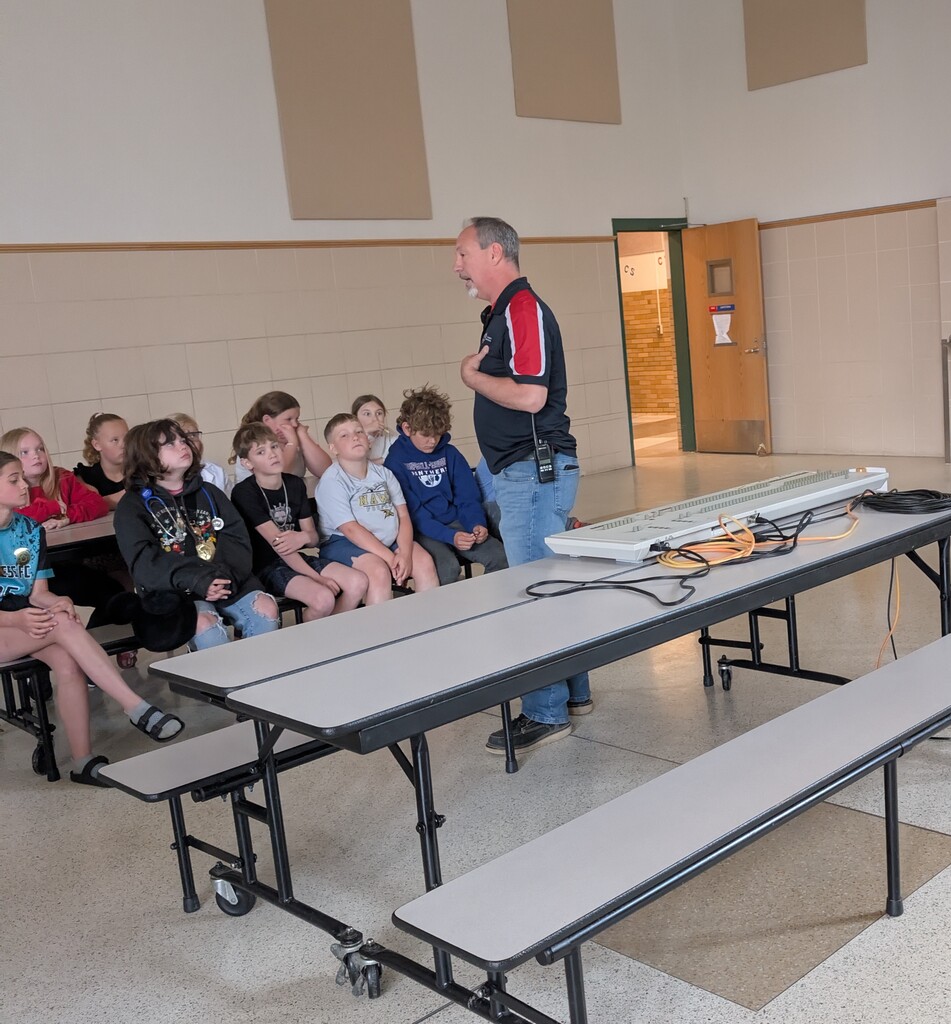 Man speaking to group of students in cafeteria