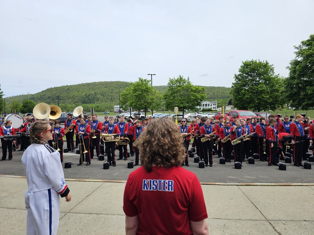 Band director looking at marching band in uniforms