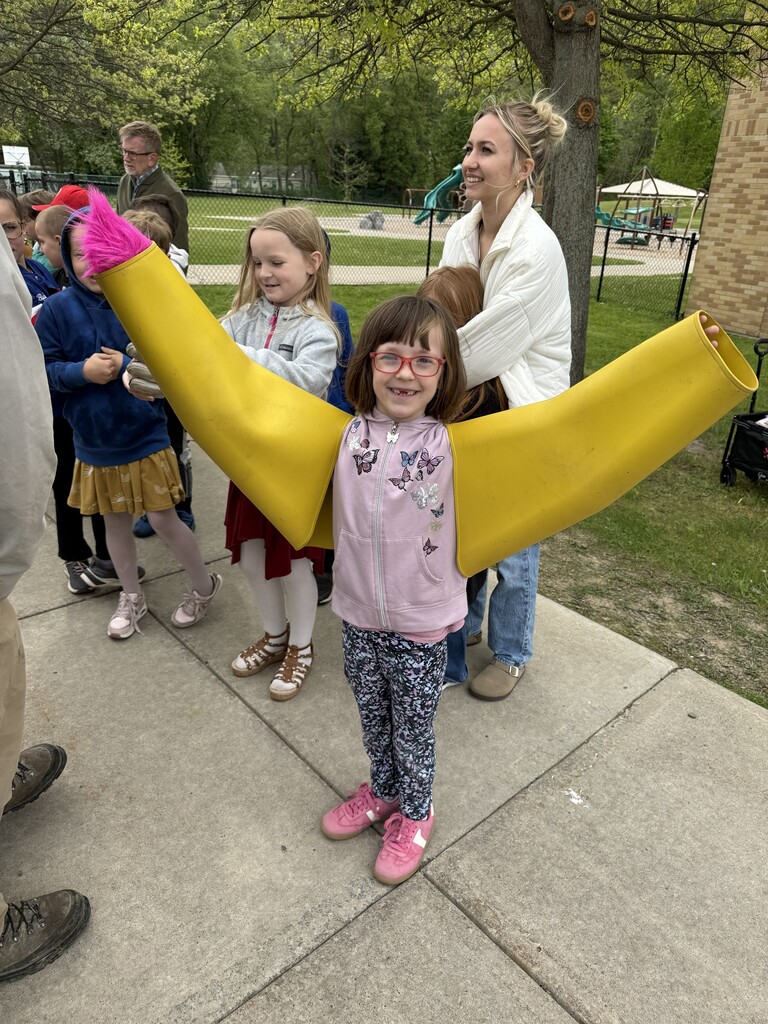 Student with glasses and big yellow covers on her arms