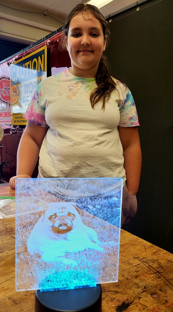 Student showing off a 3d glass picture.