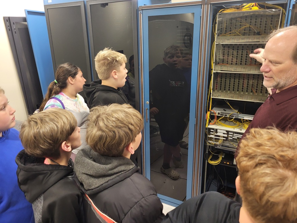 Students looking at a server rack with an adult talking to them