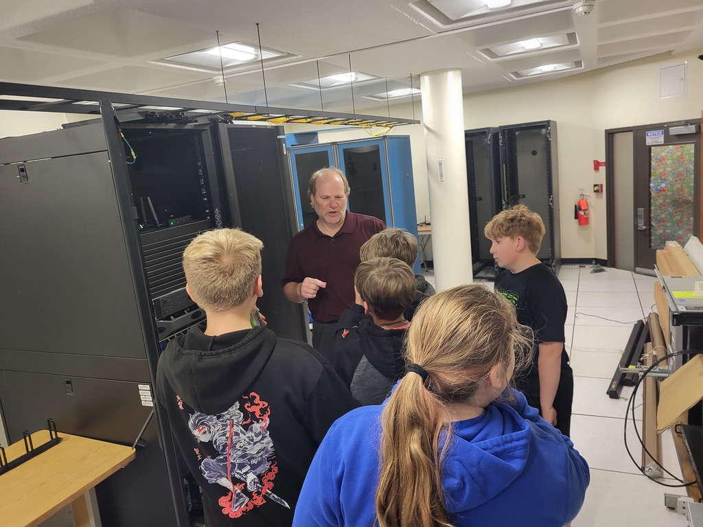 Students looking at a server rack with an adult talking to them