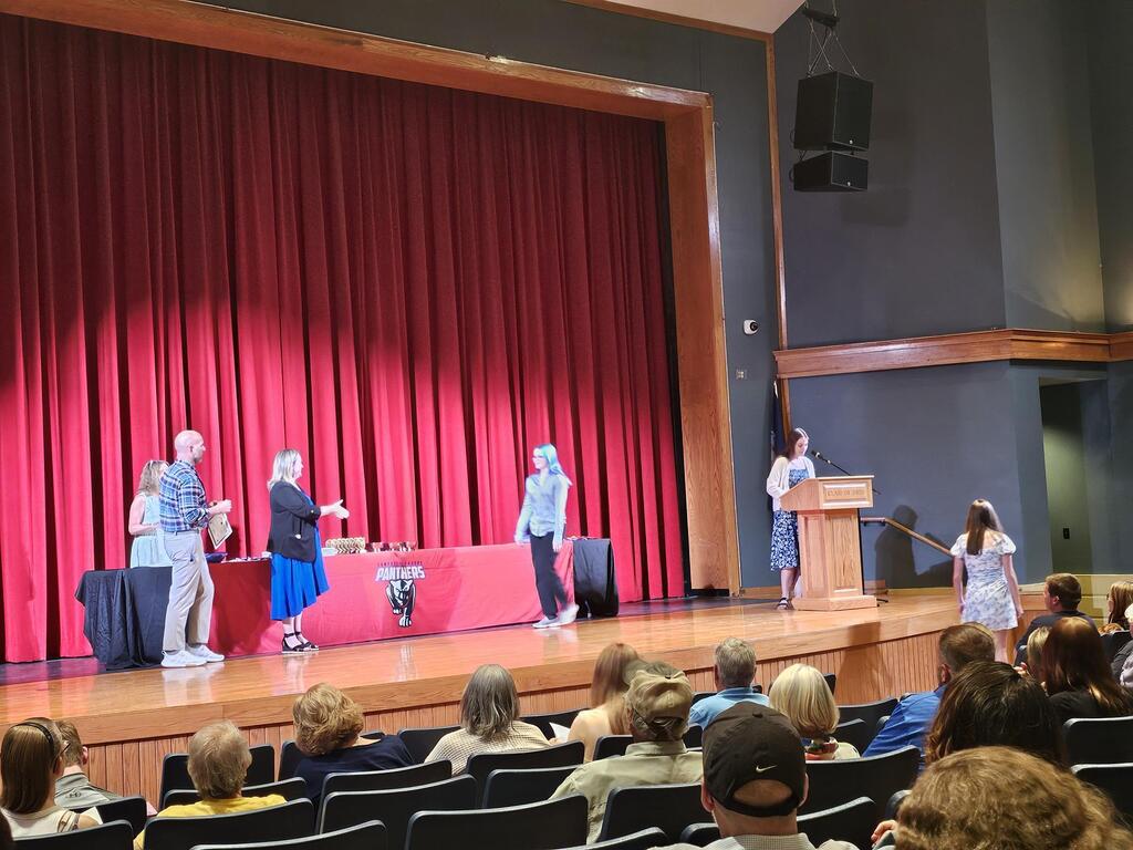 Student walking across stage to recieve award.