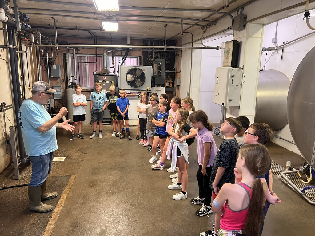 Students standing in a milking bay with a presenter