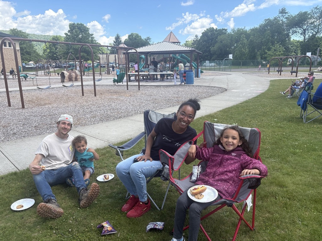 Family sitting outdoors on the playground for a picnic