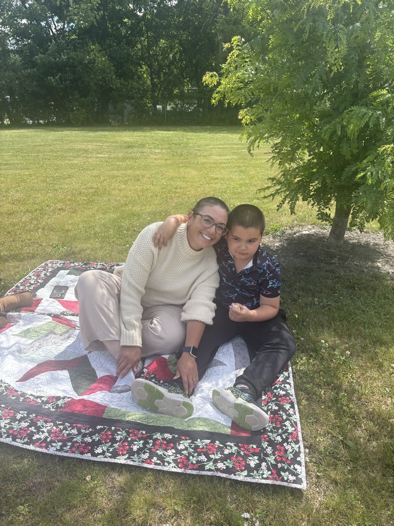 Mother and son sitting on blanket outside for a picnic