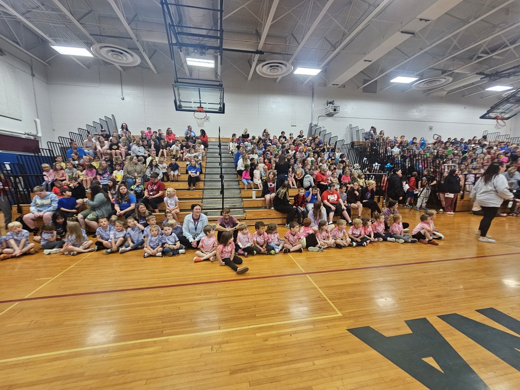 Wide shot picture of gymnasium bleachers filled with students.