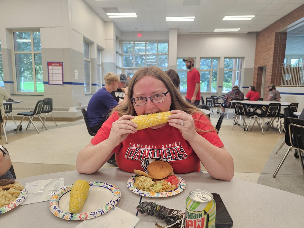Girl in red shirt eating corn on the cob