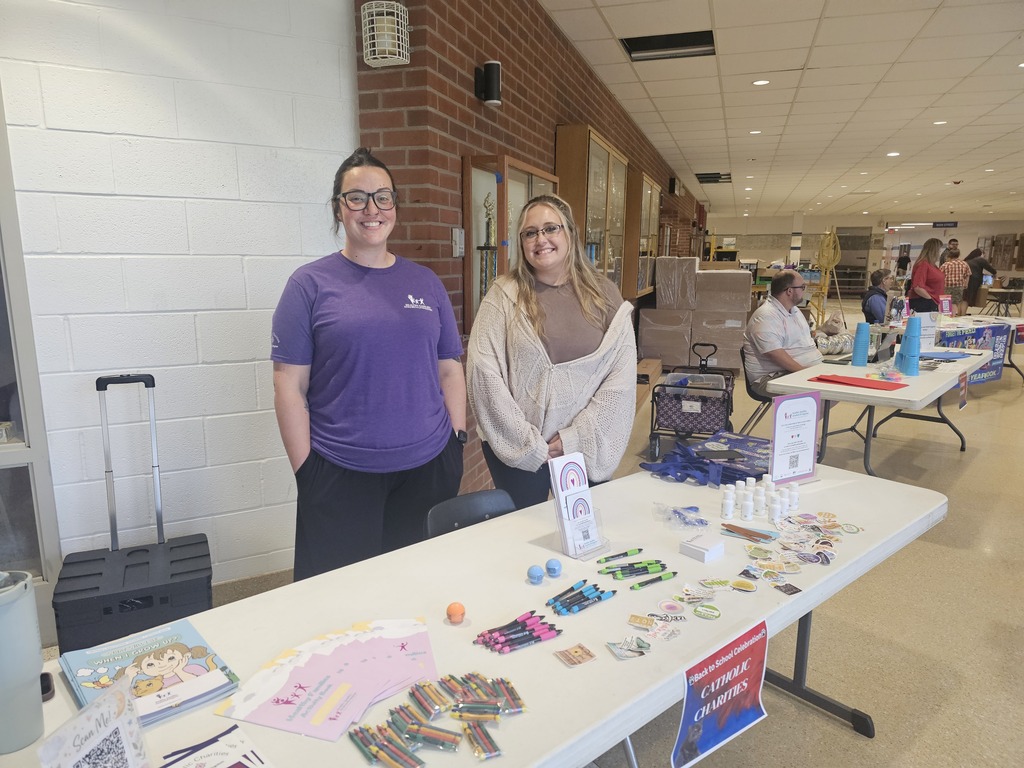 2 adults posing in front of table