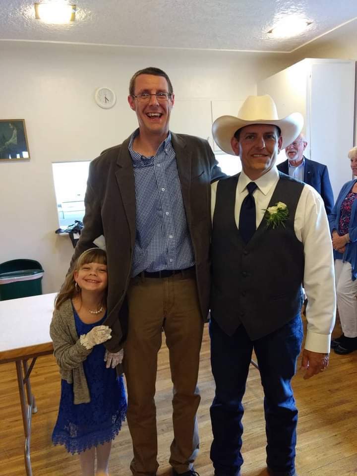 2 men and small chjild smiling for camera