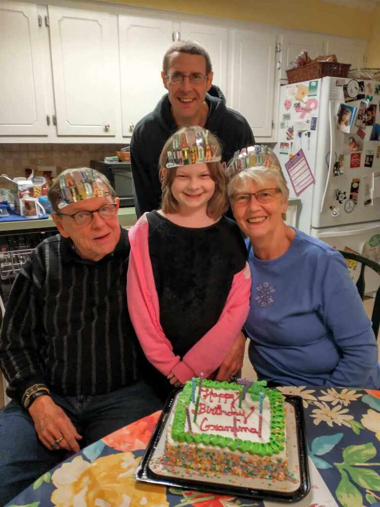 Four people celebrating birithday posing for picture