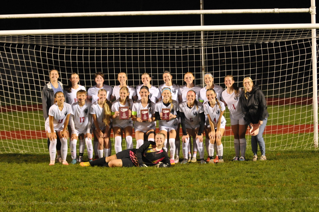 Picture of soccer team posing in front of goal.