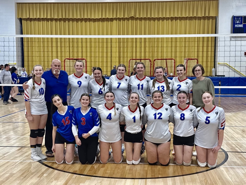 CSB Volleyball team picture in front of net