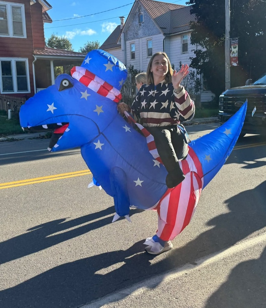 Patriotice teacher riding a dinasour