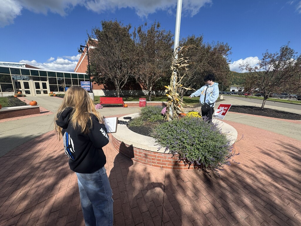 Students around flagpole with clipboards