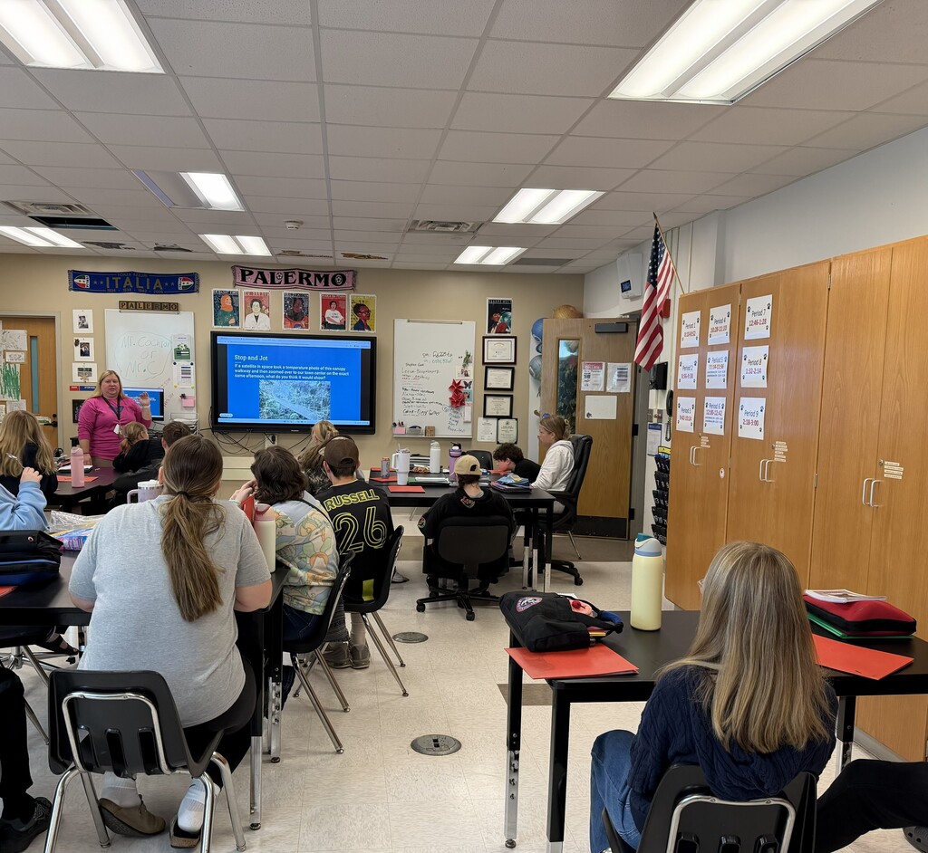 Students in classroom with teacher at front of room