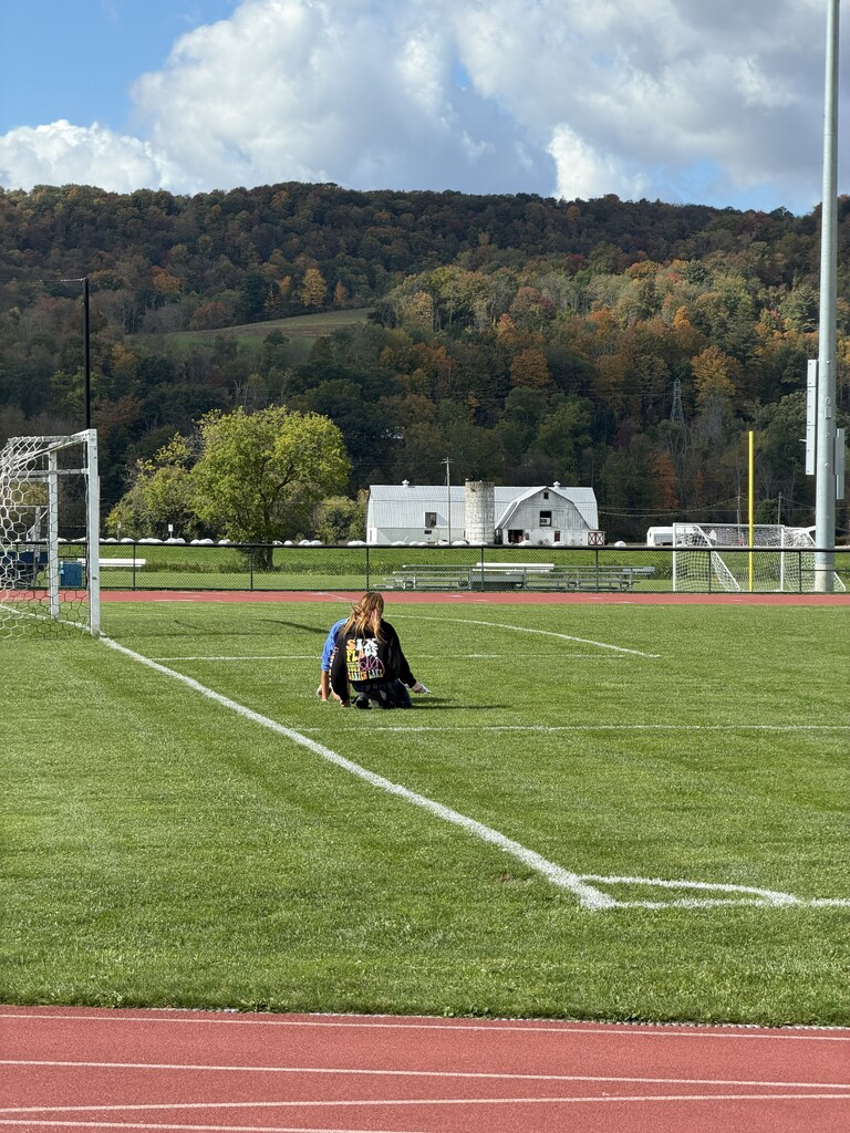 Student kneeling on soccar field