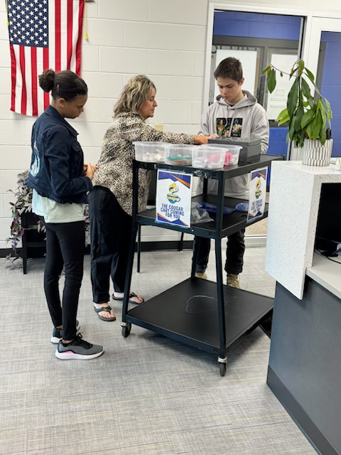 Picture of a teacher and two students delivery the items that were purchased from the Cougar Cafe