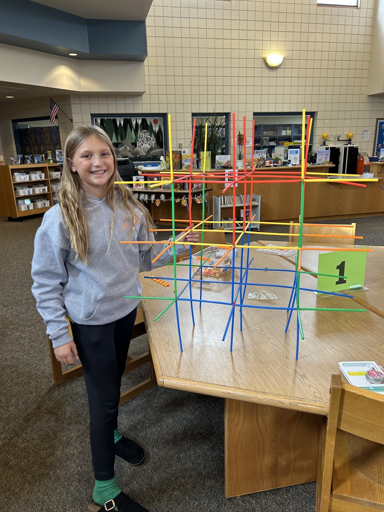 Student showing off their straw tower creation