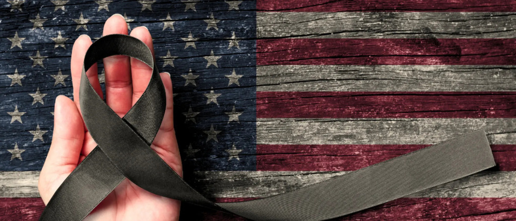 Prisoners of War Rememberance Day.  American Flag with a pair of hands on the flag.  11th November Veterans Day.  Honoring all who served