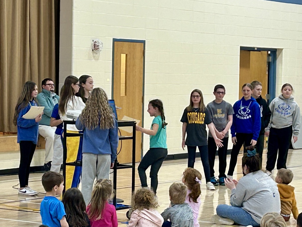 Student council members giving a student their cougar in action award