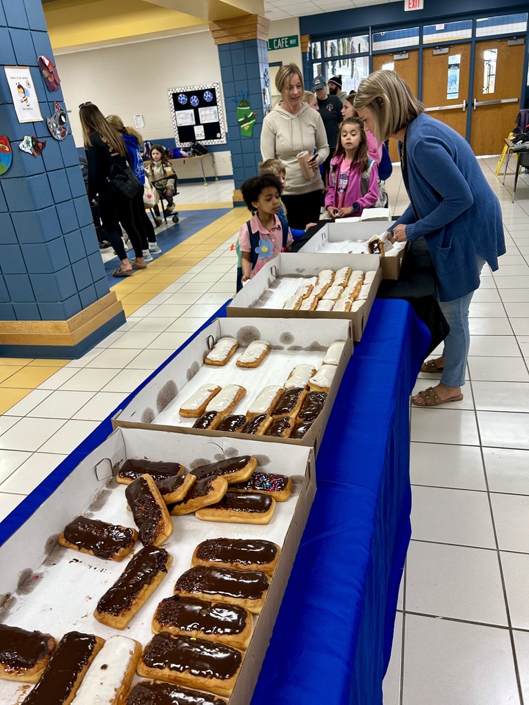 Table with donuts, donuts being handed out