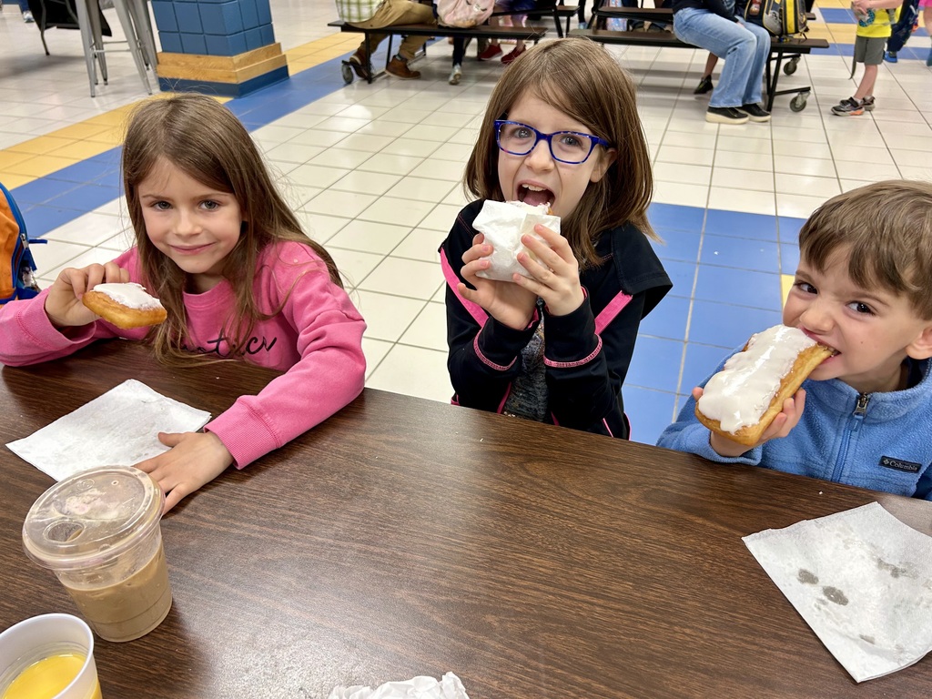 Three children, eating donuts