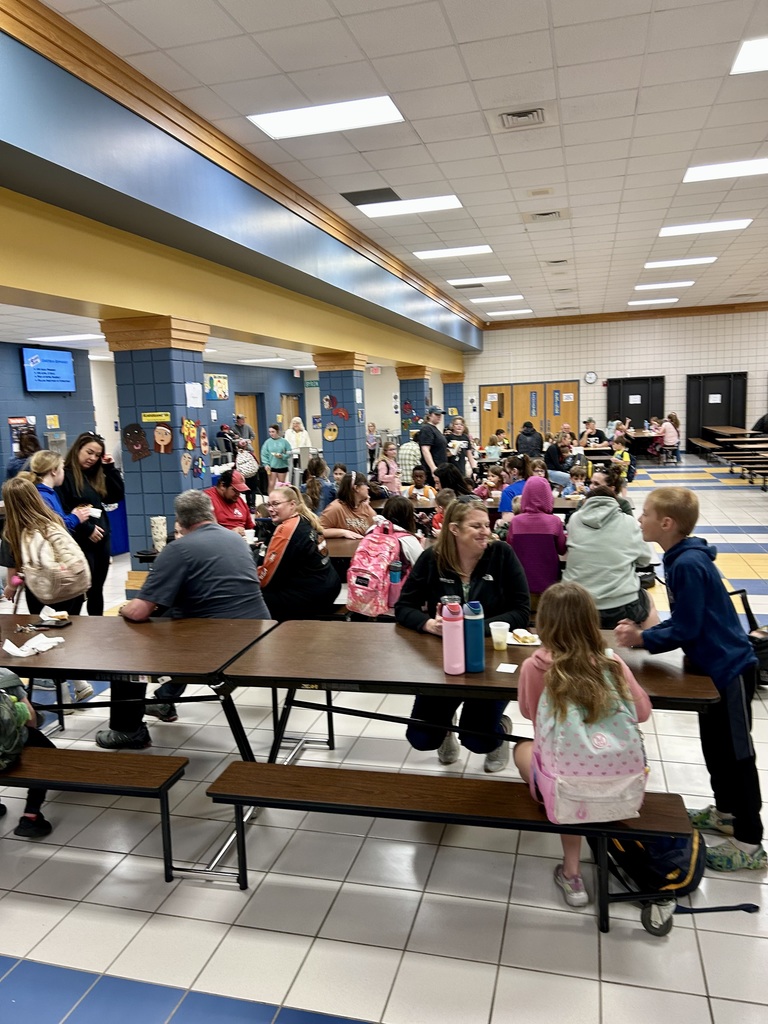 View of the cafeteria, full of parents and students eating donuts
