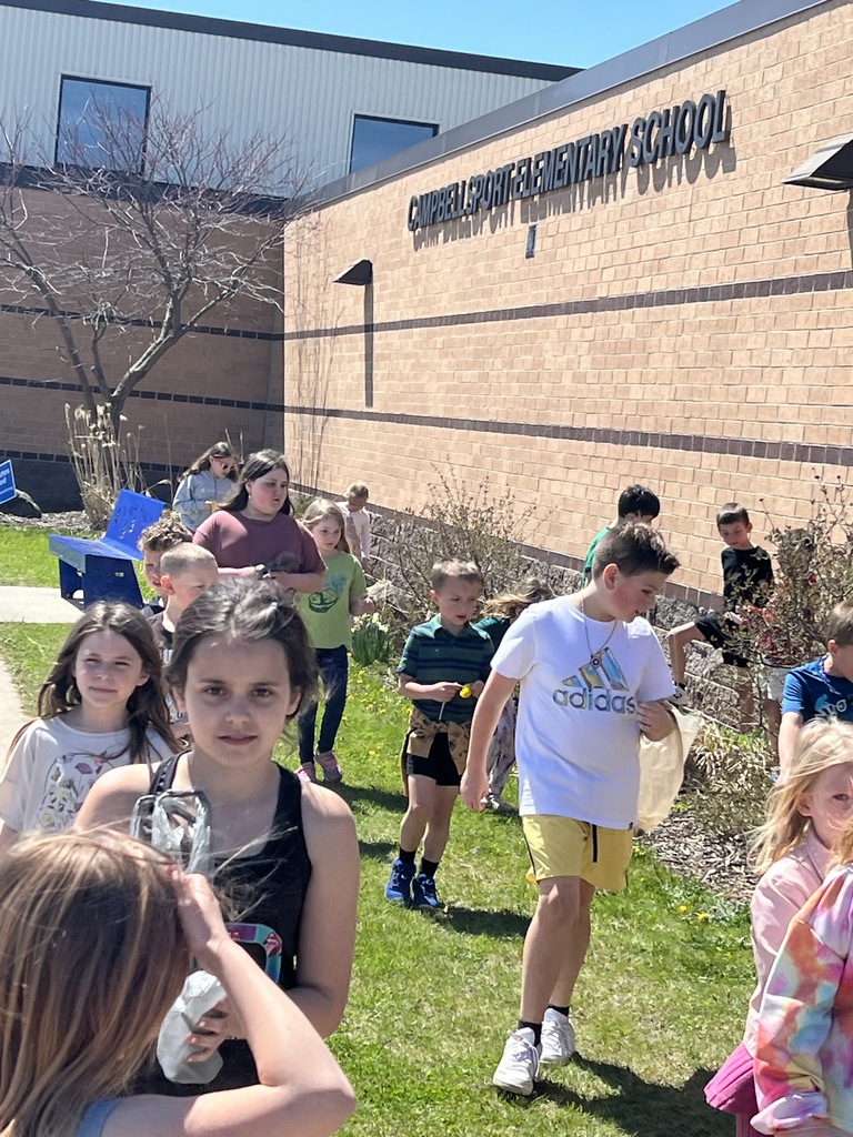 First and fourth graders walking school grounds to look for garbage