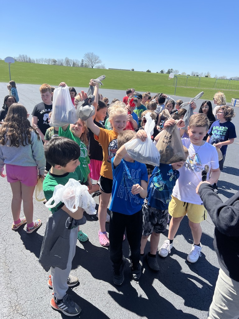 First and fourth graders showing off all the trash they picked up