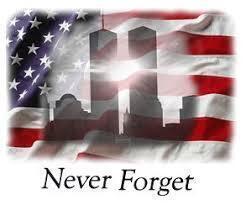Picture of US flag wavering in the breeze with a picture of the Twin Towers in the shadows with the words Never Forget