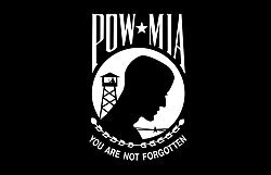 POW-MIA_flag in black and white. You are not forgotten with a picture of a persons head and a watch tower in the background