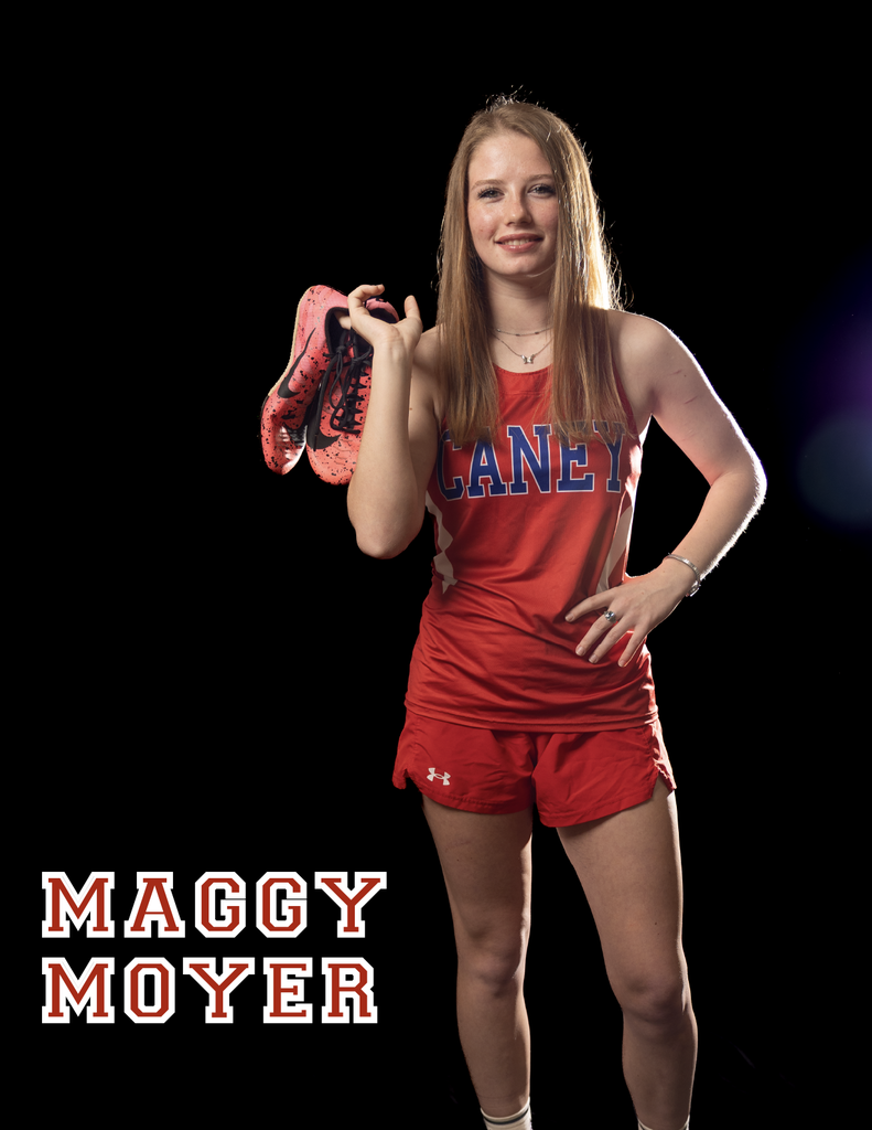 Maggy Moyer holding her track shoes over her shoulder