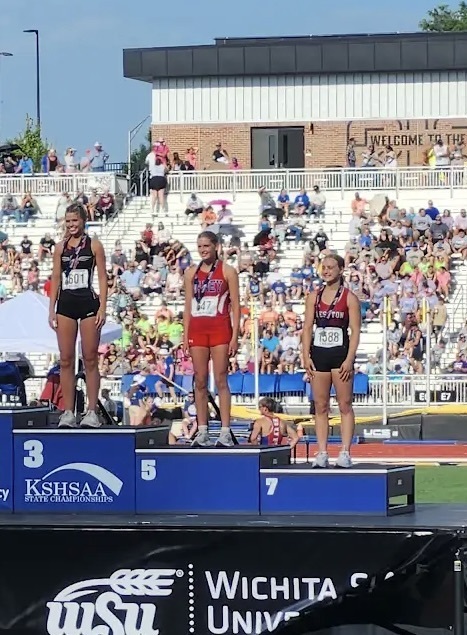 Elyn Washburn stands on the podium at the State track contest at Wichita State University.