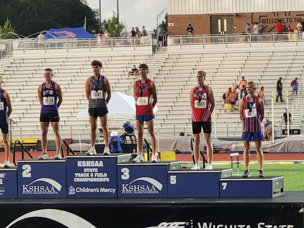 Simeon Sanchez standing on the third place block of the podium at Wichita State University