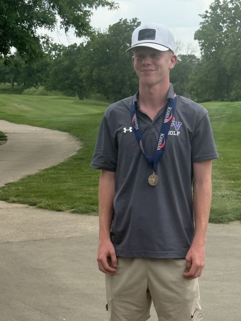 Layne Denny with medal stands on the cart path with greens in the background at the state golf tournament.