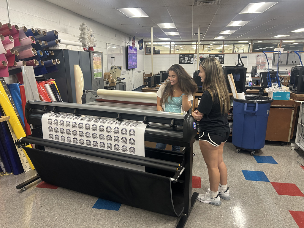 High School Students smile as they  work on projects in Mr. Murdock's Graphics classes. 