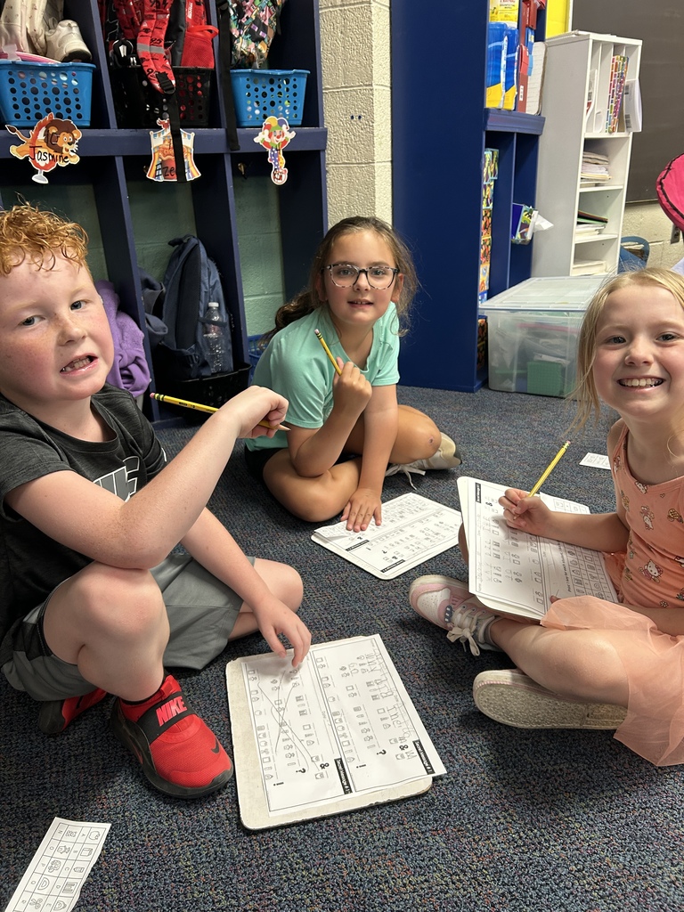 Lincoln students sit criss cross applesauce while they work on a class assignment.