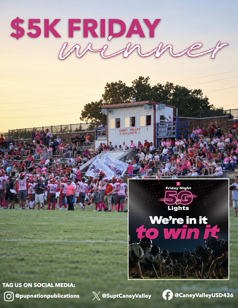 Caney Valley football players and cheerleaders gather along the sideline as a large crowd, many dressed in pink, fills the historic stone stadium.
