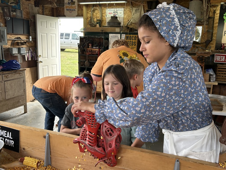 students grinding corn