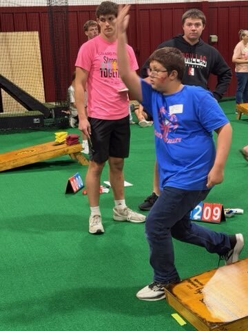 Boy throwing cornhole bag