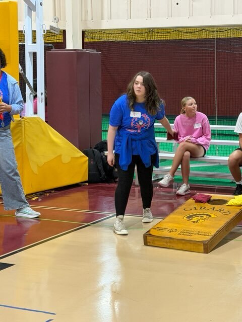 Girl throwing cornhole bag